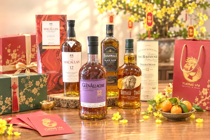 Các chai whisky Macallan, GlenAllachie, Bushmills, Buffalo Trace và Balvenie bày cùng hộp quà Tết và túi quà Tường Vy